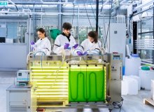 Scientists in a laboratory with an installation full of algae