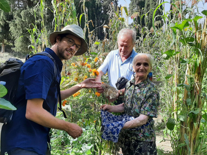 Pandora (rechts) overhandigt preizaden uit haar eigen moestuin aan Rik Lievers (links) en Ndoc Faslia (achter).