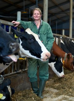 Ingrid van Dixhoorn standing between cows