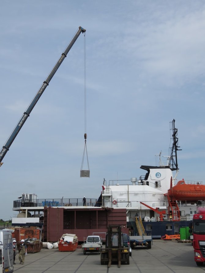 De vogelbox wordt aan boord gehesen.