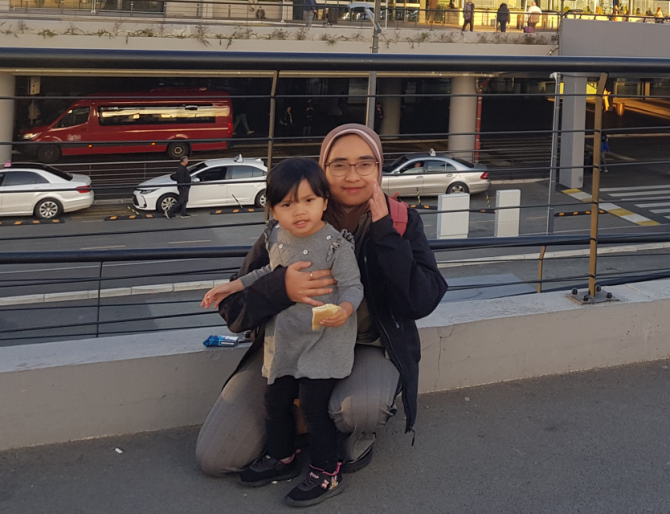 Isnawati with her daughter during her PhD track