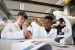 Leerlingen onderzoeken algen tijdens het Junior Science Lab.