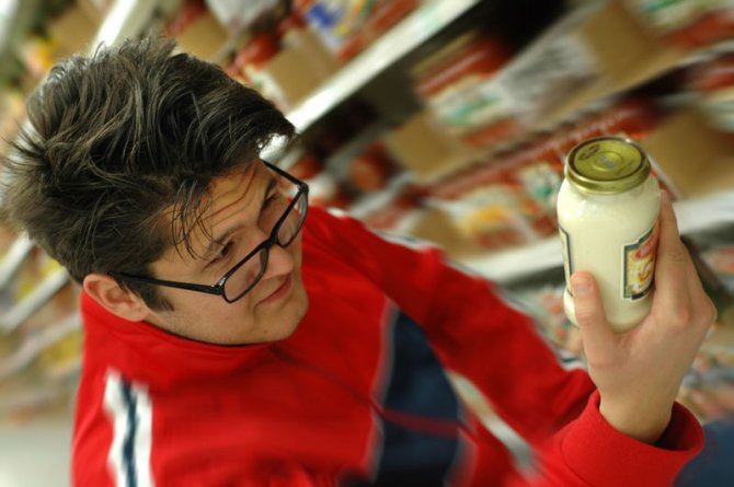 Man leest etiket in supermarkt