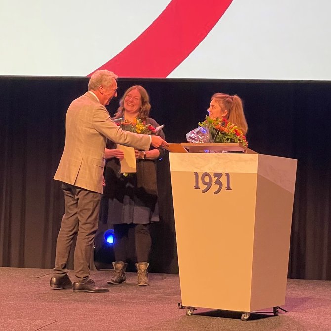 CPAD-voorzitter Henk Jan Ormel reikt de CPAD-prijs uit aan Sophie van Oort en Romy Dreskens (rechts) tijdens de biotechnische dagen.